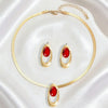 Gold necklace set featuring three oval red gemstone pendants and a gold chain.