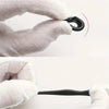 A hand in a white glove is shown gripping a black silicone anti-slip ear hook.