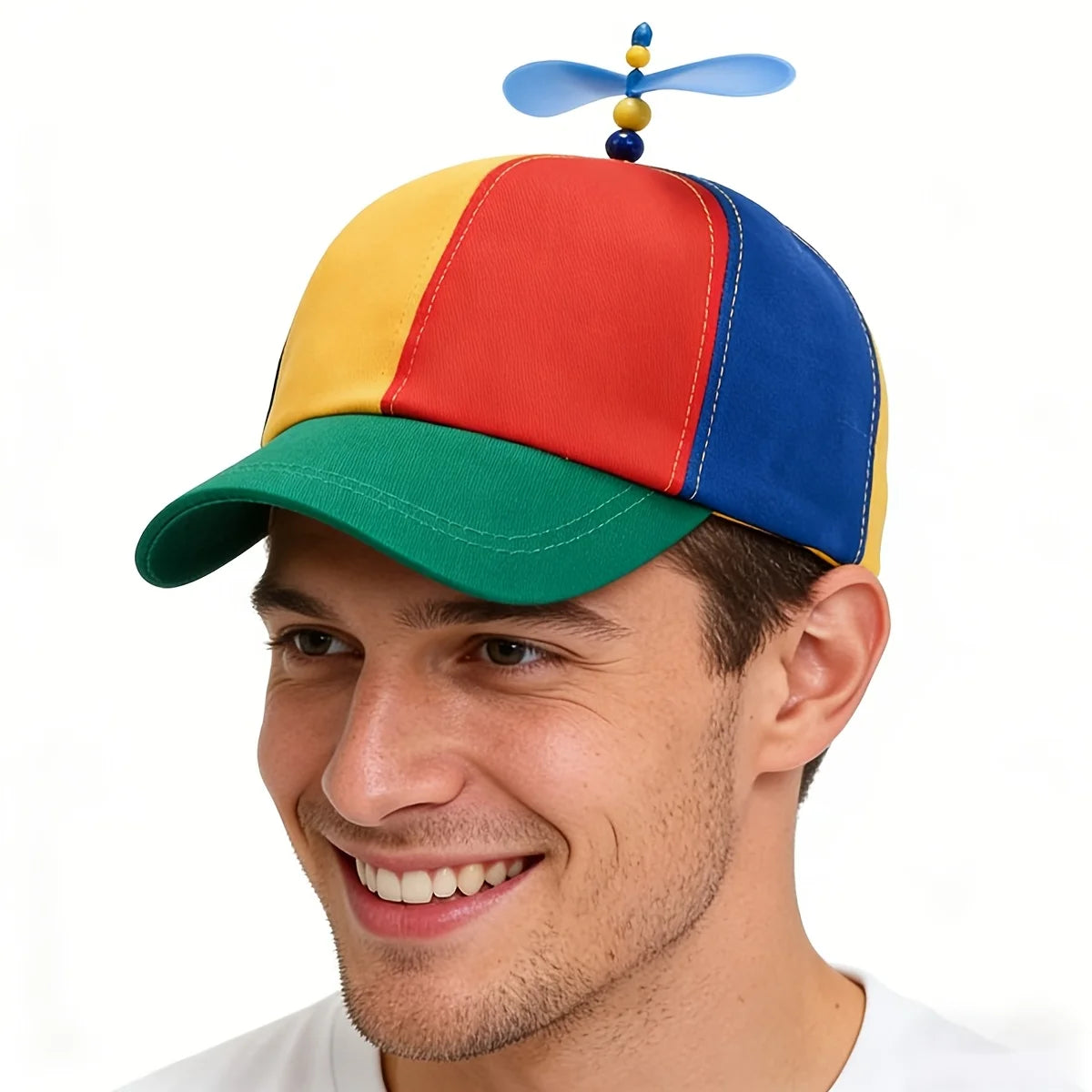 A man wearing a funny multicolor propeller hat with red, yellow, and blue panels.