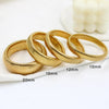 A stack of gold-colored elastic bangle bracelets with various diameters shown on a white surface.