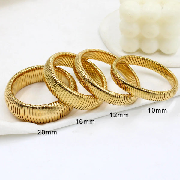 A stack of gold-colored elastic bangle bracelets with various diameters shown on a white surface.