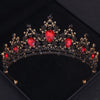 Couronne or foncé avec des accents de gemmes rouges et des détails floraux complexes.