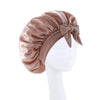 A satin wide-brimmed hair wrap headscarf in a dusty rose color tied with a bow, displayed on a white mannequin.