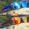 A pair of gradient square frame polarized sunglasses in blue and orange colors resting on a rock.