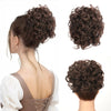 A woman's hair styled in a voluminous, dark brown synthetic curly chignon or messy bun.