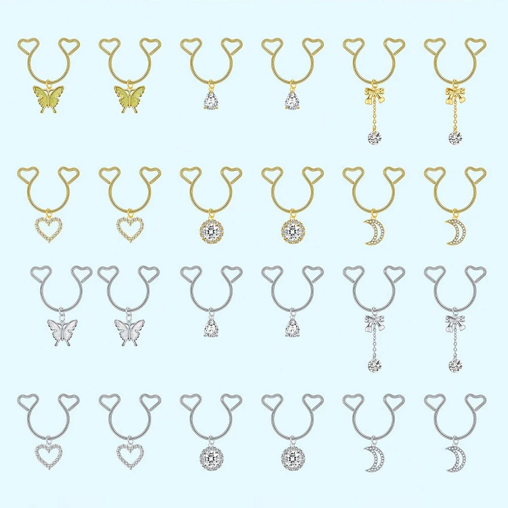 A collection of heart-shaped dangle non-piercing nipple rings with cubic zirconia in various gold tones.