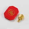 A red hexagonal tag with a gold circular emblem and a small gold turtle charm.