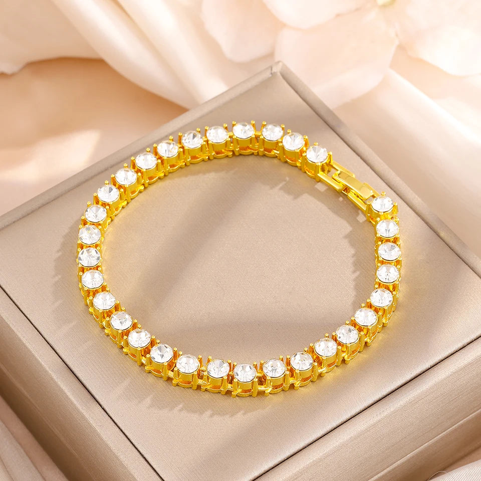 A gold-toned geometric rhinestone heart stacking bracelet set displayed in a square box.