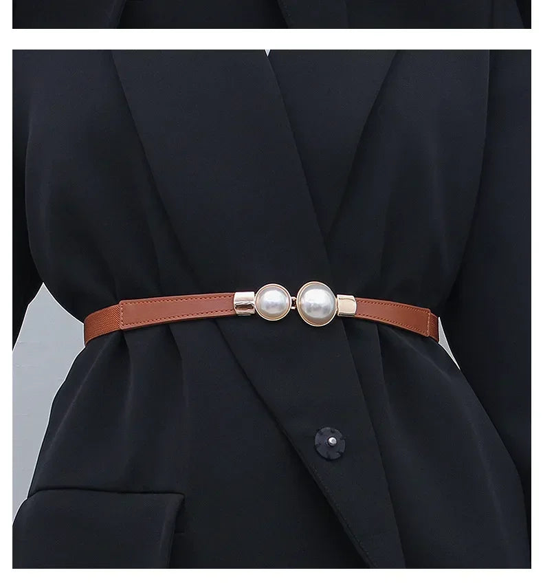 Nahaufnahme eines braunen Ledergürtels mit Perlenakzenten, getragen an einem schwarzen Blazer.