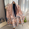 A pink and beige plaid cashmere feel scarf and shawl wrap displayed on a hanger.
