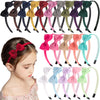 A collection of decorative grosgrain ribbon hair bows in various colors and shades displayed alongside a girl's hair.