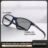 A pair of dark blue photochromic reading glasses resting on a white surface.