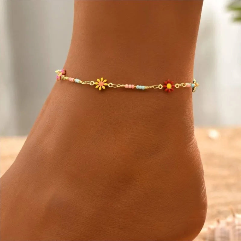 Zartes goldenes Margrietkette-Armband, getragen am Knöchel.