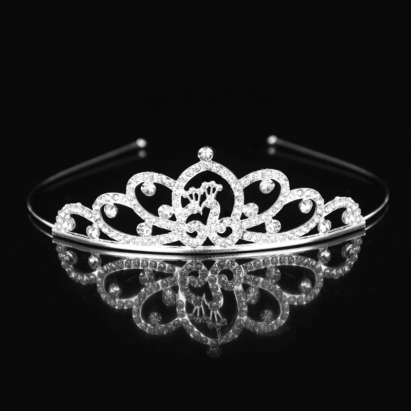 Tiara y corona de princesa de cristal brillante para el cabello, exhibida sobre una superficie reflectante.