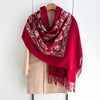 A deep red luxury floral scarf draped over a beige blazer.