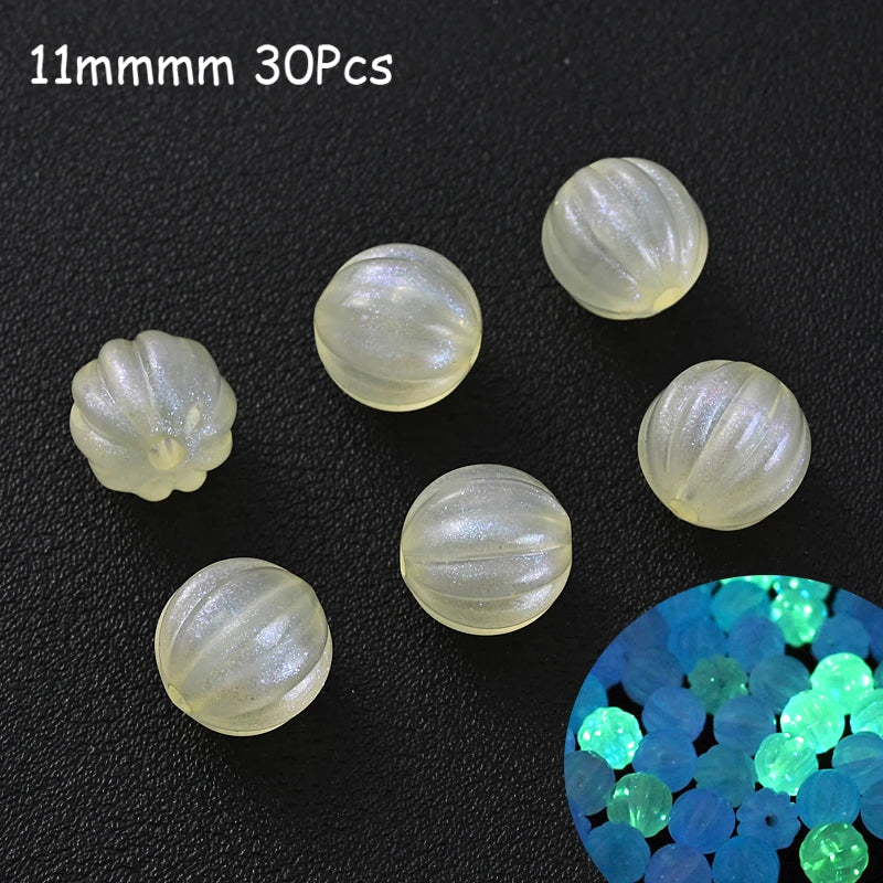 Thirty clear luminous glow-in-the-dark acrylic beads scattered on a dark surface with a close-up of blue and green glowing be
