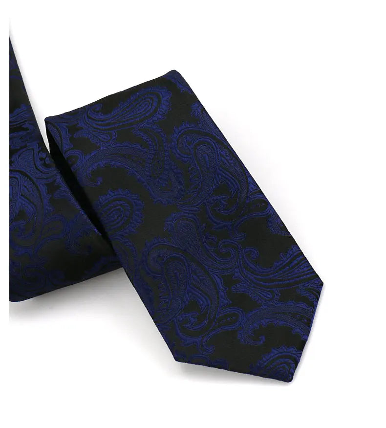A dark blue paisley silk necktie with a black background and intricate blue floral patterns.