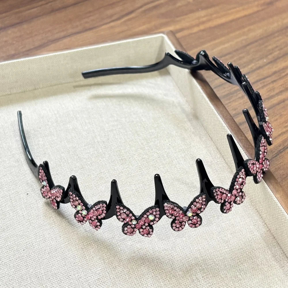 A black sparkling butterfly clip headband displayed in a light box.