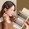 A hand holds a set of vintage frosted geometry hair clips in various shades against a brown background.