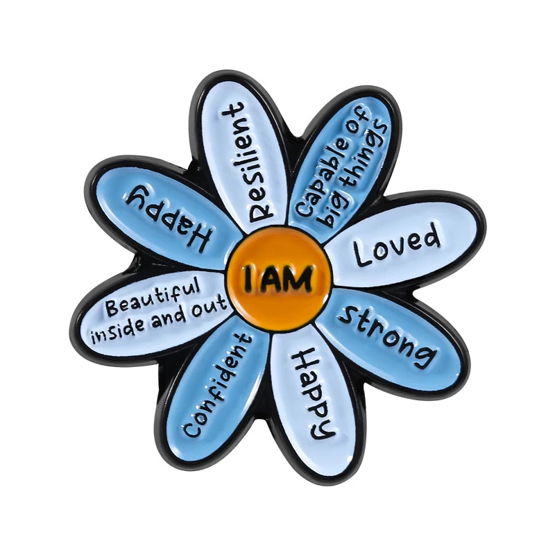 A flower-shaped enamel brooch featuring various positive words like Resilient Happy Loved and Strong inside the petals.