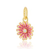 Adorno de cuenta tono dorado con diseño floral rosa y blanco y piedra central brillante.