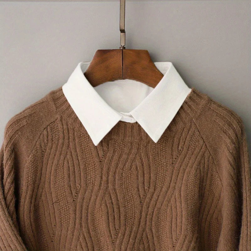 A brown knitted sweater with a white collar displayed on a wooden hanger.