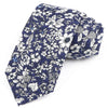 Cravate en coton à col bleu foncé avec motif floral, fleurs blanches et bleu clair.