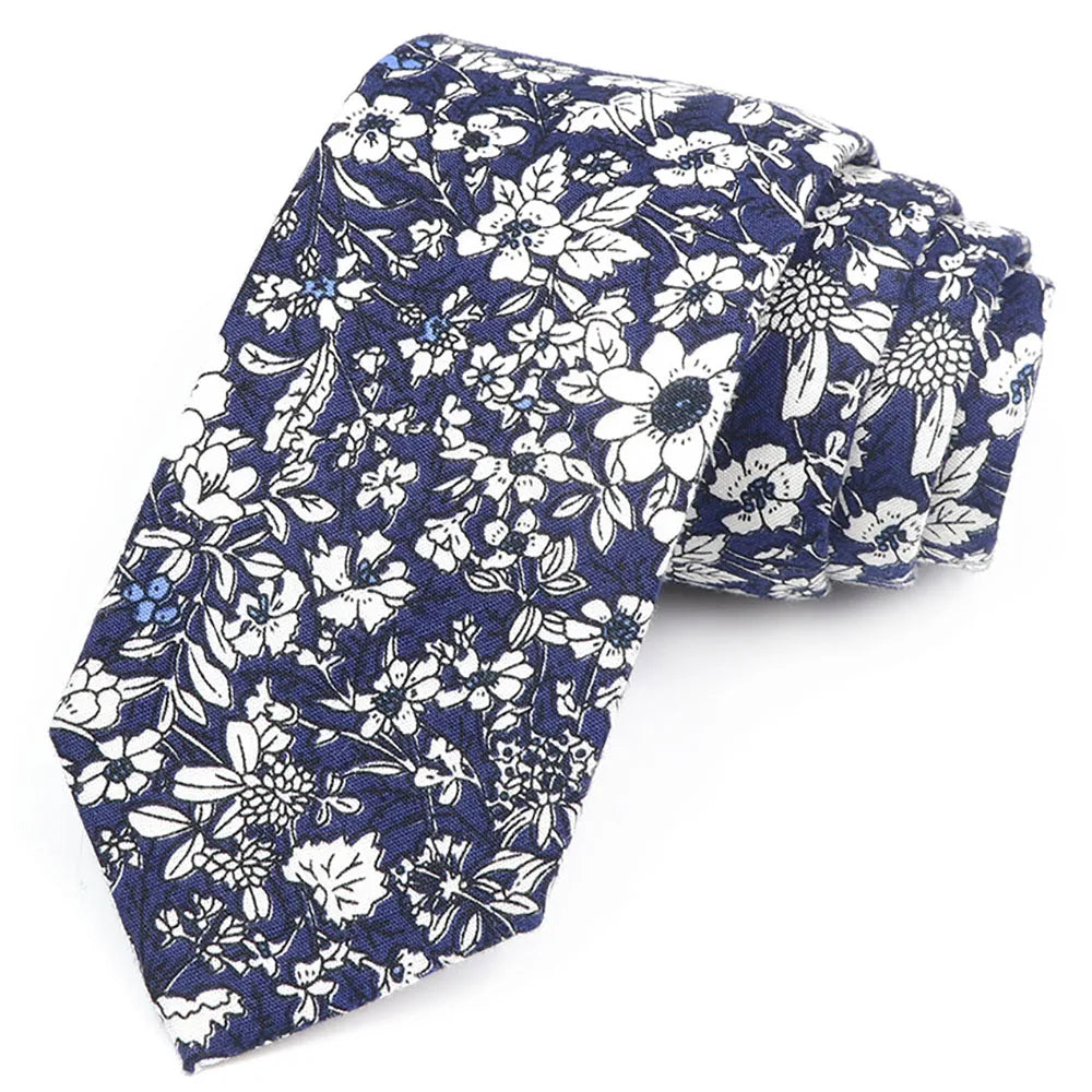 Cravate en coton à col bleu foncé avec motif floral, fleurs blanches et bleu clair.