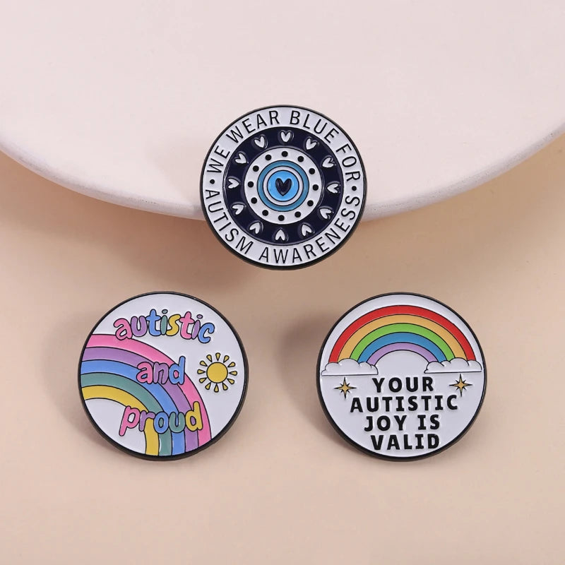 Three enamel lapel pins featuring designs for autism awareness and acceptance.