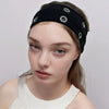A close-up of a woman wearing a black punk style metal hollow headband with silver studs.
