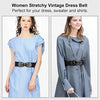 A woman models a women stretchy vintage dress with a black leather belt and brass buckle.