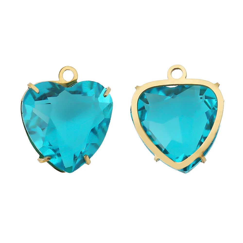 A pair of heart-shaped crystal pendants with a vibrant blue-green color set in gold-toned stainless steel.