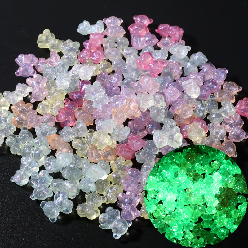 A pile of luminous glow-in-the-dark acrylic beads in various shades of pink, white, and yellow, with a large green sphere.