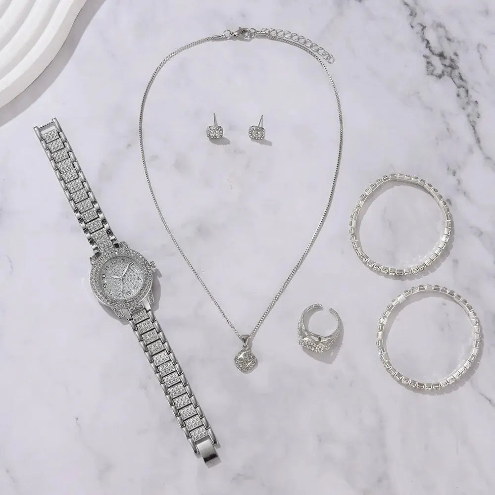 Eine Sammlung eleganter Quarzkristallschmuckstücke, darunter eine Halskette, Ohrringe und mehrere Ringe, präsentiert auf weiß