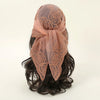 A sheer, dusty rose floral embroidered lace bandana headscarf tied around dark hair.