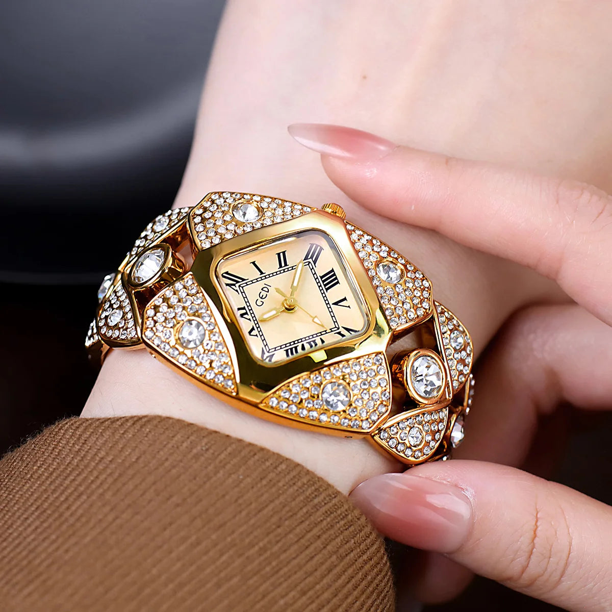 A close-up of a luxury diamond inlaid quartz wristwatch with a gold casing and sparkling stones on a person's wrist.
