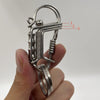Une main tient un porte-clés mécanique en acier inoxydable avec ressorts et maillons visibles.