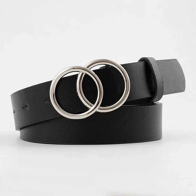 Schwarzer Kunstledergürtel mit zwei silbernen Ringen, flach auf weißem Hintergrund.