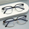 A pair of retro half gold frame anti blue light eyewear resting on a white surface.