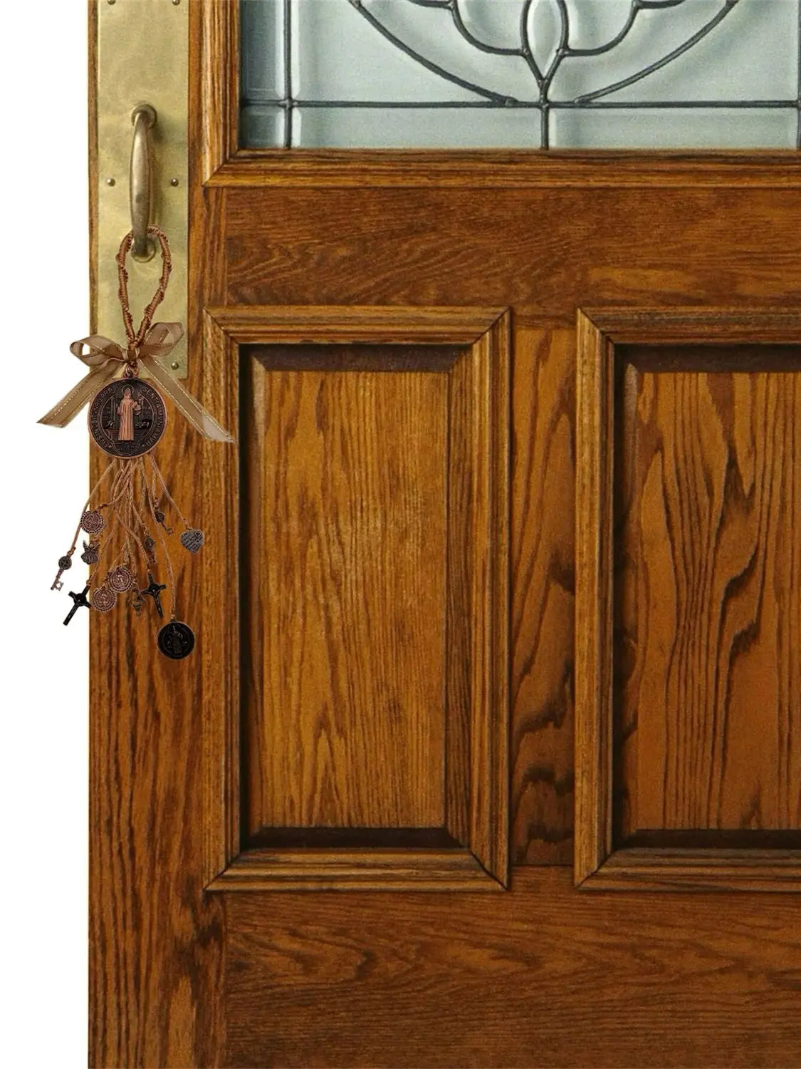 A close-up of a wooden door featuring a glass panel and a hanging charm set with a cross and beads.