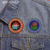 Denimjacke mit runder Anstecknadel mit dem Text Dumpster Fire Response Team Leader