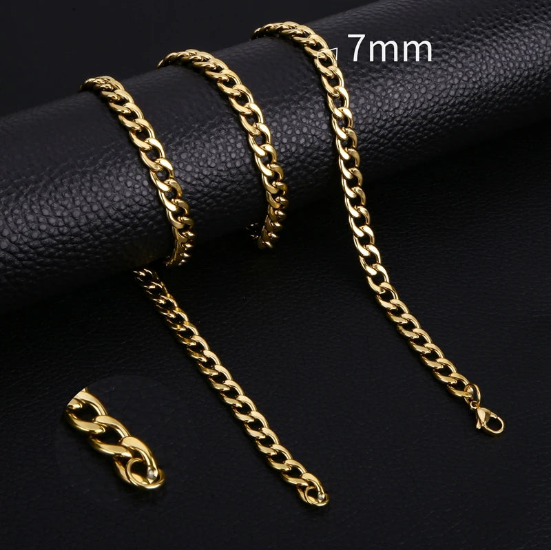 Gold-colored stainless steel Cuban link necklaces of various lengths displayed on a black surface.