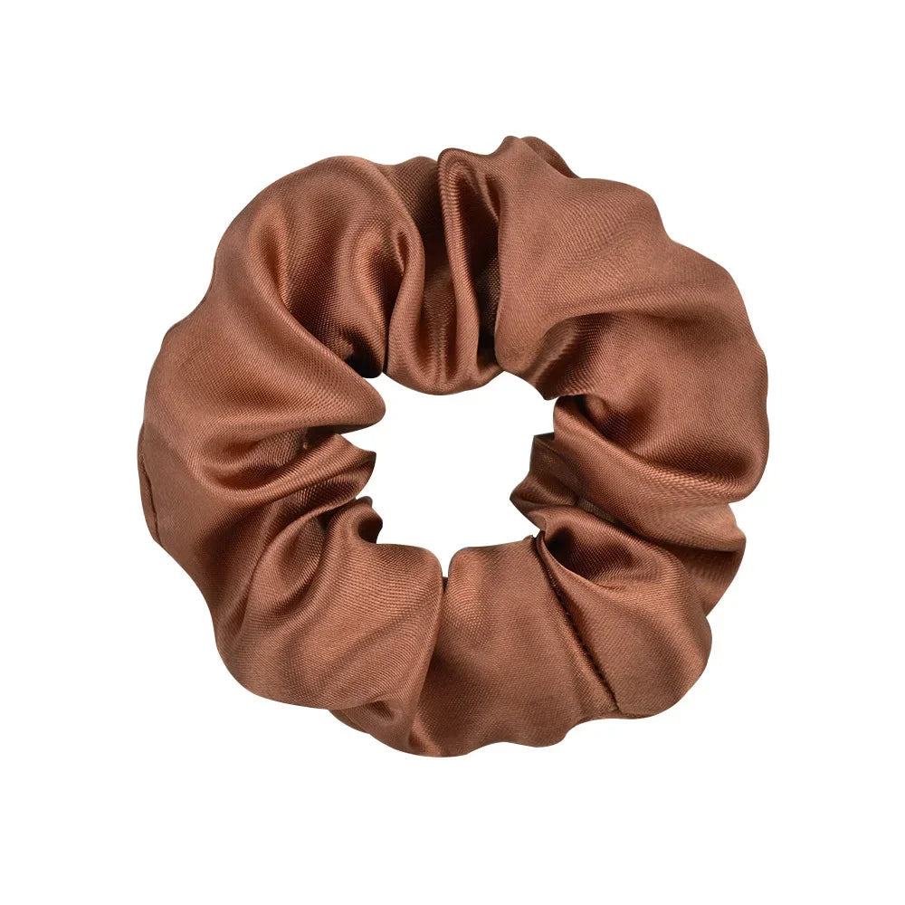 A brown satin scrunchie tied in a circular shape.
