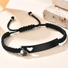 Schwarzes Perlenarmband mit silbernem Herzcharm auf weißem Untergrund neben Seife.