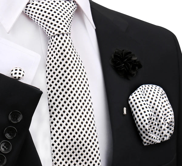 A black suit jacket displays a white and black checkered tie and a black floral lapel pin.
