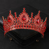 Tiare et couronne en strass de cristal rouge brillant, présentés sur une boîte en velours noir.