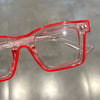 A pair of red plastic costume glasses with a square frame and clear lenses.