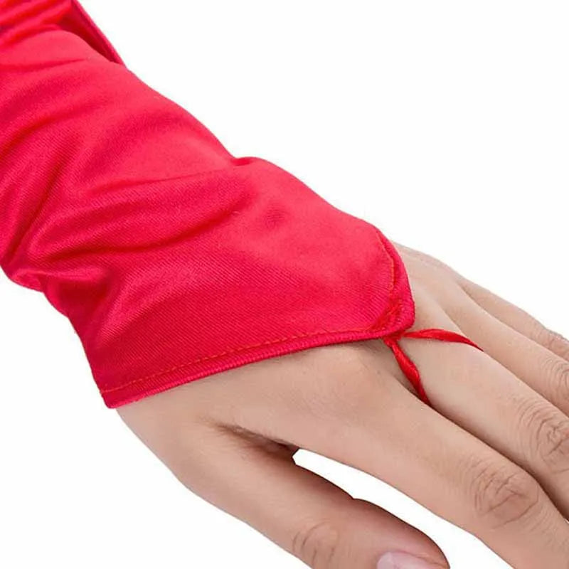 A close-up of a hand wearing bright red satin fingerless gloves.