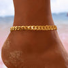 A gold multi-chain stainless steel anklet worn on a person's ankle against a blurred background.