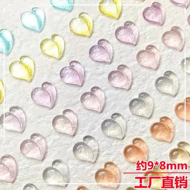 A collection of 10 pink and white resin heart-shaped nail art charms on a white background.